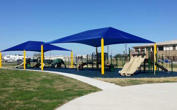 Playsystem at a school with blue and yellow shade shelters digitally in picture