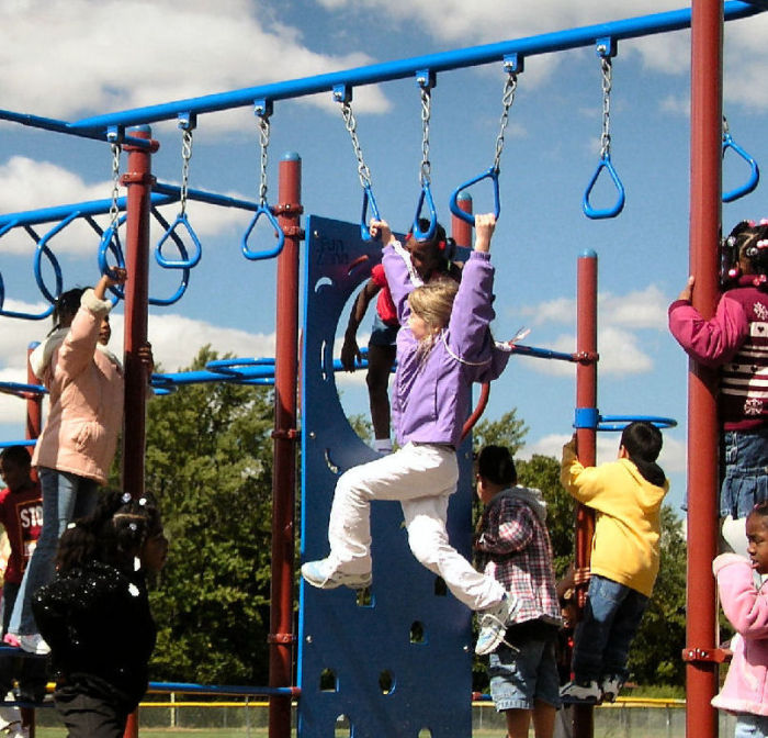 Child playing on swinging rings on playground